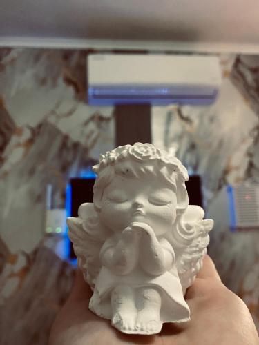 a hand holding a white statue of a bust at Ledi’s Home in Borsh