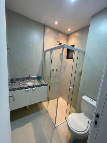 a bathroom with a glass shower and a toilet at White Life in Caruaru