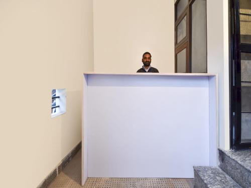 a man standing behind a counter in a building at Hotel O Pragati Inn in Jaipur