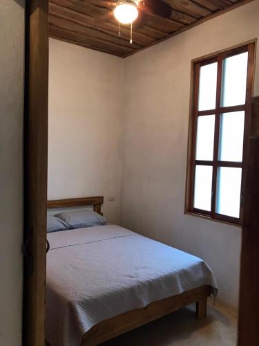 a bedroom with a bed and a window at Fuga Ecolodge casa de campo in Carara