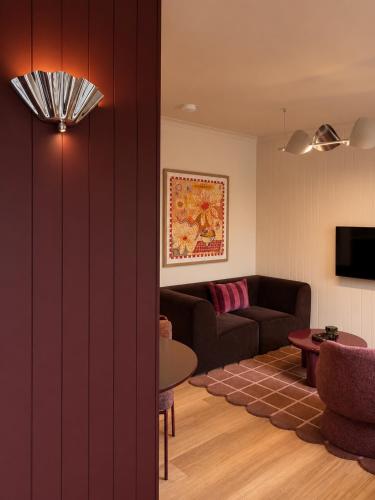 a living room with a couch and a table at The Bron Apartment - newly renovated, designer stay in Yarralumla