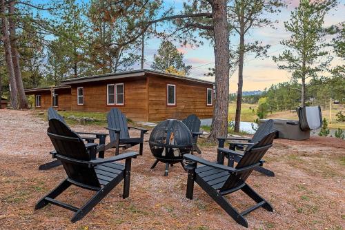 a group of chairs around a fire pit in front of a cabin at Hottub Hideaway: Firepit; Sauna; Views; Wildlife in Custer