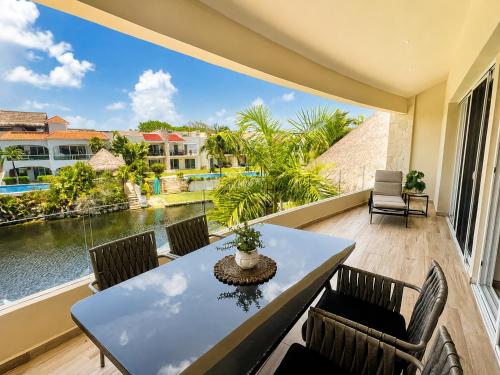 a balcony with a table and chairs and a view of the water at Lagoonfront Apartment with Pool and Beach Access in Puerto Aventuras