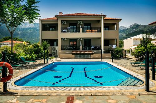 a house with a swimming pool in front of a building at Green Sea Apartments in Skala Potamias