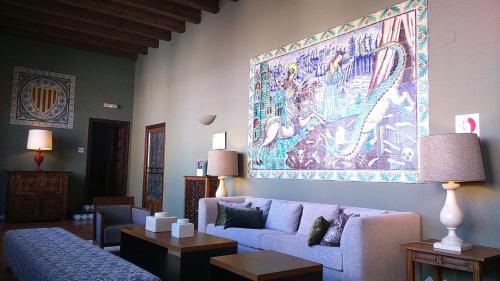 a living room with a couch and a painting on the wall at Parador de Alcañiz in Alcañiz