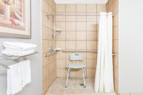 a shower with a white chair in a bathroom at Super 8 by Wyndham Wytheville in Wytheville