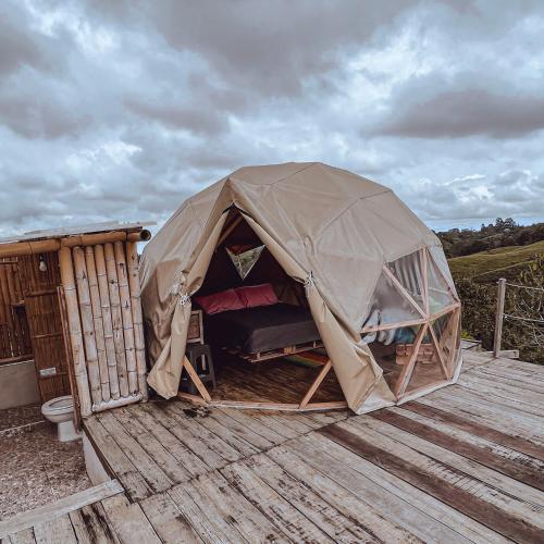 a tent sitting on top of a wooden deck at La Alborada Glamping in Filandia