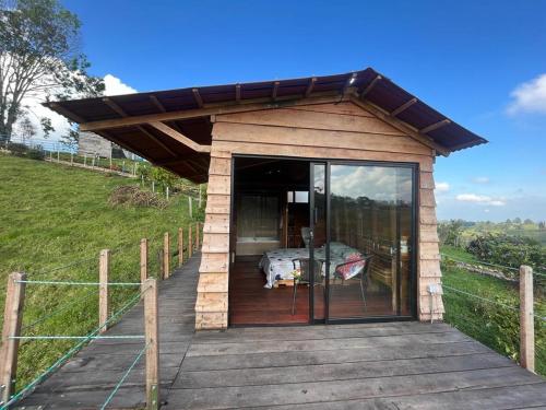 a small house with a glass door on a deck at La Alborada Glamping in Filandia