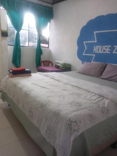 a bedroom with a large bed with a blue headboard at House the Cats in Panajachel