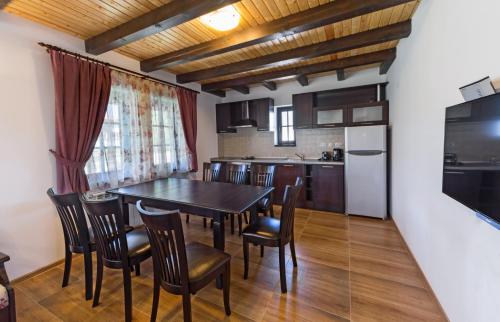 a kitchen and dining room with a table and chairs at Complex Rayuvski Han in Rayuvtsi
