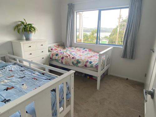 a bedroom with two bunk beds and a window at Mangōnui Harbour Haven in Mangonui