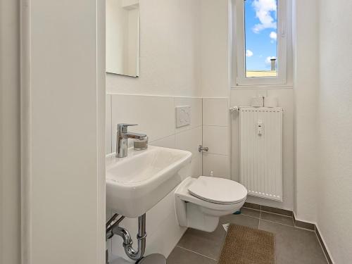 a white bathroom with a sink and a toilet at Loft 24 Stuttgart Zentrales Gruppenloft für 10 Gäste mit PS5 in Stuttgart