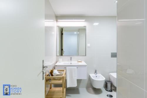 a white bathroom with a sink and a mirror at Almada Story Apartments by Porto City Hosts in Porto