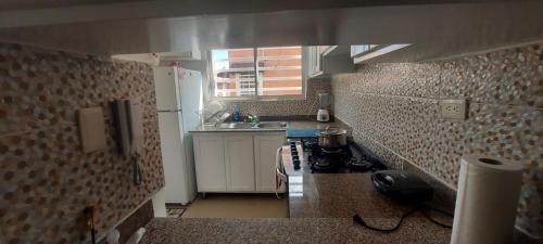 a small kitchen with a sink and a stove at La cubana in Santo Domingo