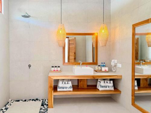 a bathroom with two sinks and a mirror at Yamore Villa in Gili Islands