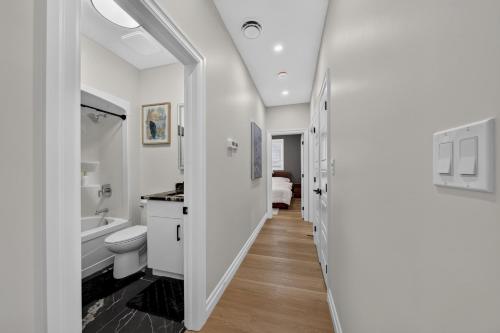 a white bathroom with a toilet and a sink at The Windsor Mainstay in Windsor