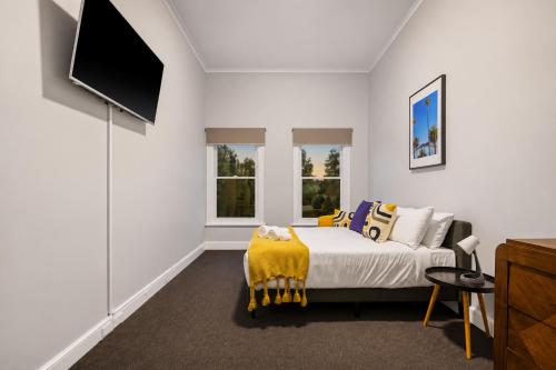 a bedroom with a bed with a yellow blanket at Heritage-Style Boutique Hotel, Port Melbourne in Melbourne