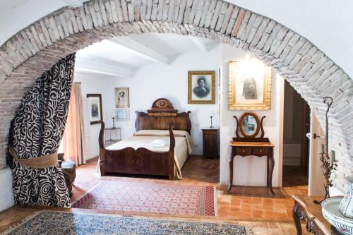 Un arco en un dormitorio con una cama. en Apartaments Can Gibert, en Castelló d'Empúries
