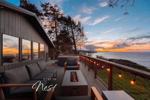 a patio with a couch and a fire pit on a balcony at Private Blufftop Oceanview Hot Tub Fire Pit in Port Angeles