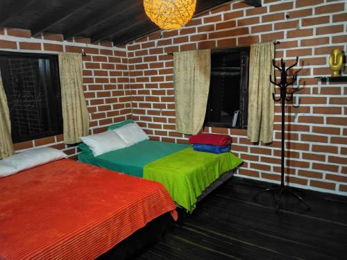 a room with two beds in a brick wall at Casa Campestre Familiar in Medellín