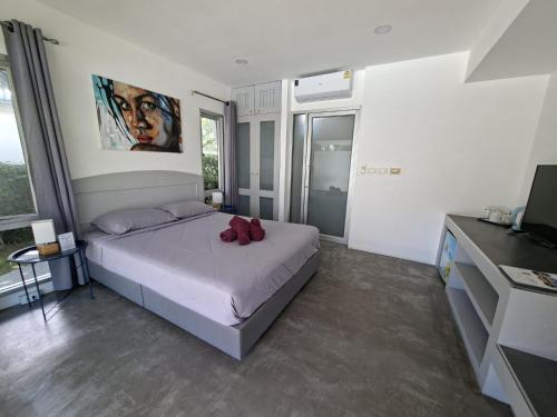 a bedroom with a bed with red shoes on it at Thiptara Resort - adults only in Mae Nam