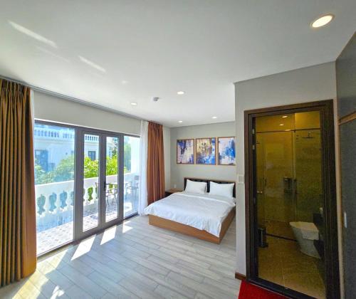 a bedroom with a bed and a large window at VIN HOTEL in Vĩnh Long