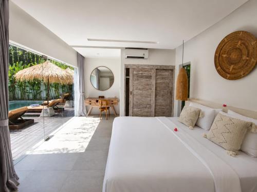 a bedroom with a large white bed and a patio at Villa Mei 2BR Pool, 200m from Seseh Beach in Dalung