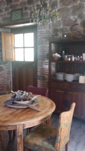 a table and chairs in a kitchen with a stone wall at La Curva De María in Terán