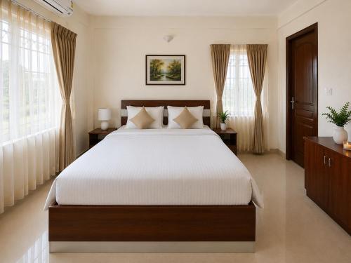 a bedroom with a large bed and windows at Serene Padmanabham Premium Luxury Apartments Near Sree Padmanabhaswamy Temple in Trivandrum