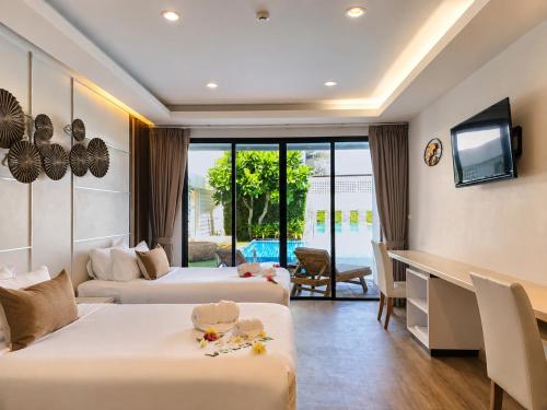 a hotel room with two beds and a television at Chaolao Cabana Resort in Chao Lao Beach