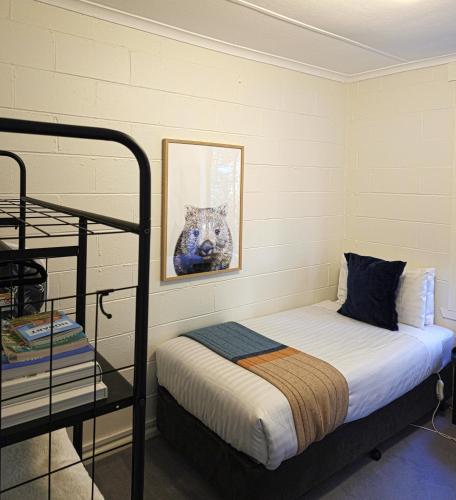 a bedroom with a bed and a cat picture at Tide & Timber - Adventure Bay in Adventure Bay