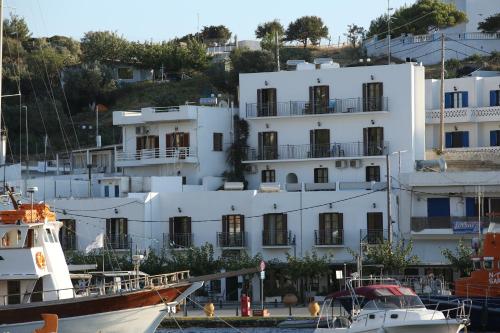 a white building with two boats in the water at Lykomides in Skiros