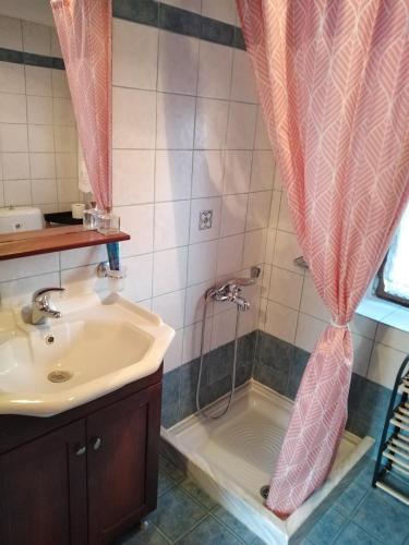 a bathroom with a shower with a sink and a shower curtain at Eternal blue in Volos