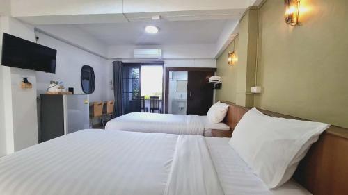 a hotel room with two beds and a television at Ratchawong Place ราชวงศ์ เพลส --หลังพ่อขุน-- in Phayao