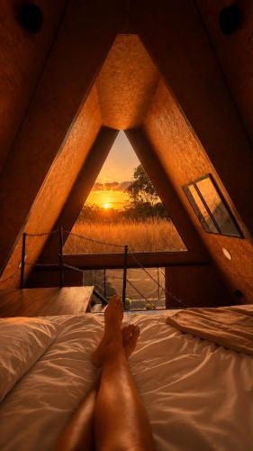 a person laying on a bed in a room with a window at Chalé Queen in Brasília