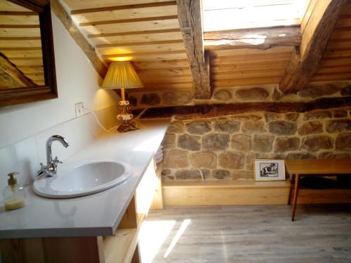 a bathroom with a sink and a stone wall at La Curva De María in Terán