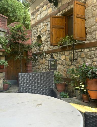 a table and chairs in front of a stone building at Urban River House in Florina