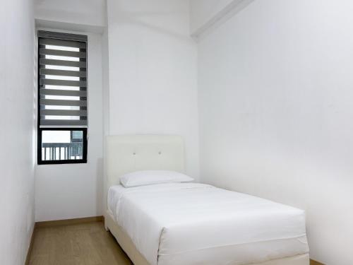 a white bedroom with a bed and a window at Atlas Serviced Suites in Butterworth