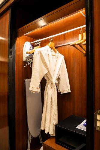 a white robe hanging on a rack in a bathroom at Savan Resorts in Savannakhet
