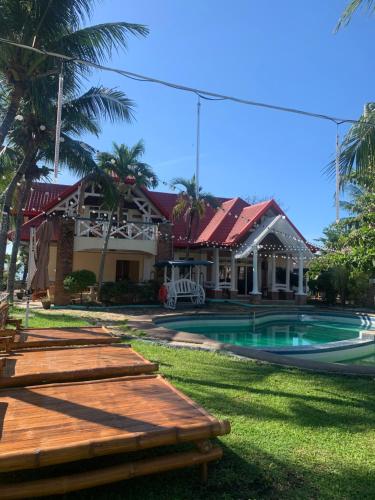 a resort with a swimming pool and a house at Dumaguete Dive Center in Mojon