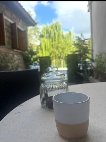 a glass jar and a cup sitting on a table at Urban River House in Florina