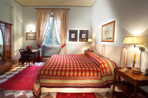 a bedroom with a bed and a table and a window at Residenza Johanna I in Florence