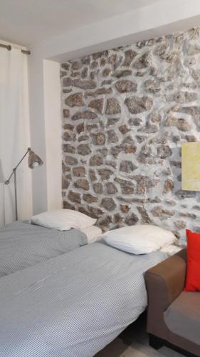 Dos camas en una habitación con pared de piedra. en Villa des iris, en París