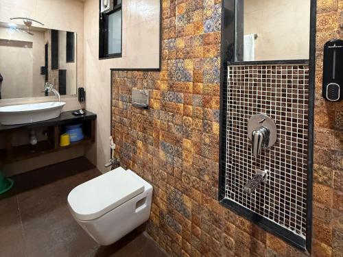 a bathroom with a toilet and a sink at Hotel Ashoka Inn in Wardha