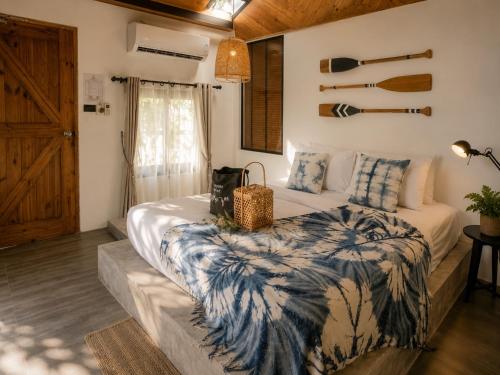 a bedroom with a bed with a blue and white blanket at Nitiporn Resort kohphayam & seaagain bar and restaurants in Ko Phayam