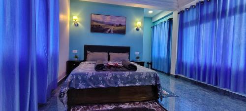 a blue bedroom with a bed with blue curtains at Lavender Guesthouse in Cherrapunji