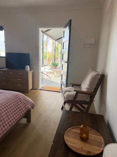 a bedroom with a bed and a chair and a table at Lamington Guesthouse in Kalgoorlie