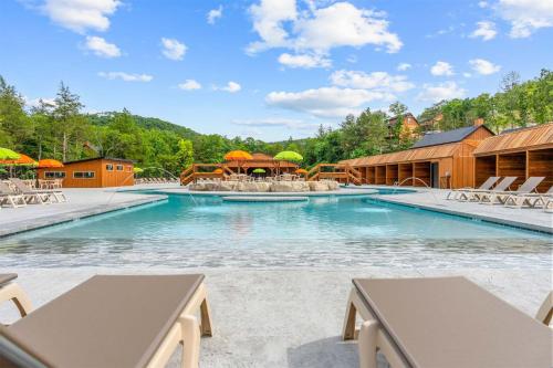 a swimming pool with chairs and umbrellas at a resort at Lumberjack Lodge with Amenities in Hollister