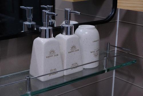 two bottles of soap are on a shelf in a bathroom at Happy Sun Hotel in Mỹ Tho