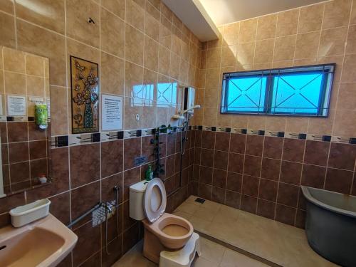 a bathroom with a toilet and a sink and a tub at MELAKA BEACH VILLA ( B TYPE ) in Malacca